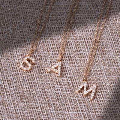 letter gold necklaces on mesh