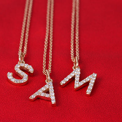 letter gold necklaces on red leather